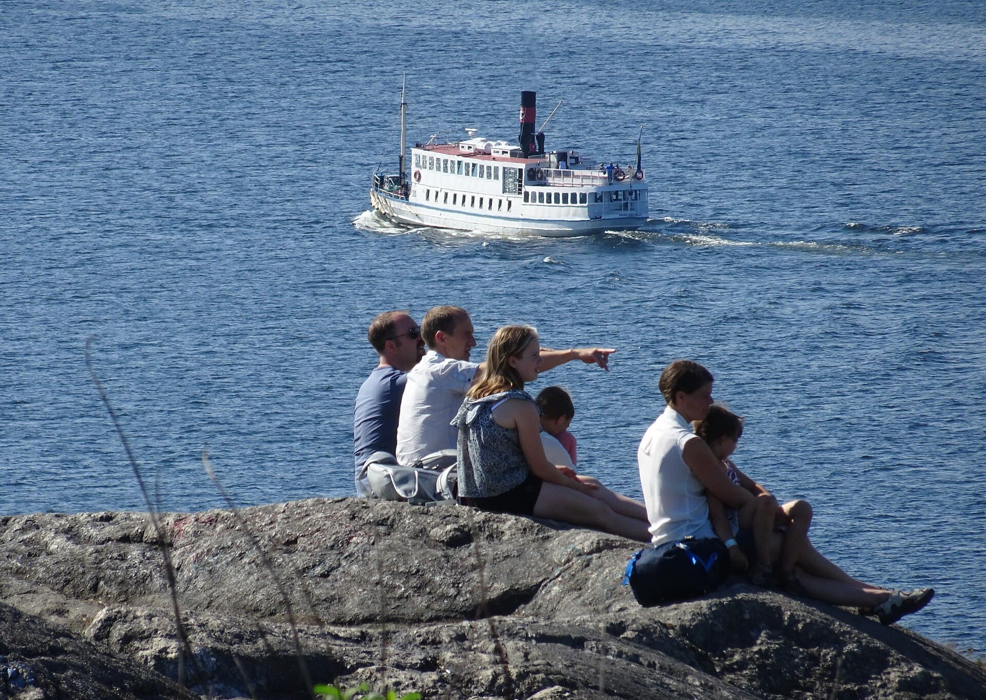 People sitting on the rock on a summer evening